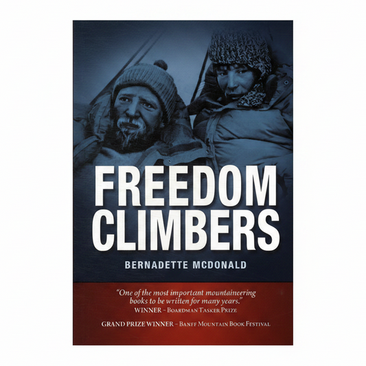 Book cover for 'Freedom Climbers' by Bernadette McDonald, featuring a dark blue-toned photograph of two mountaineers in winter gear with large white title text and a dark red review banner at the bottom.