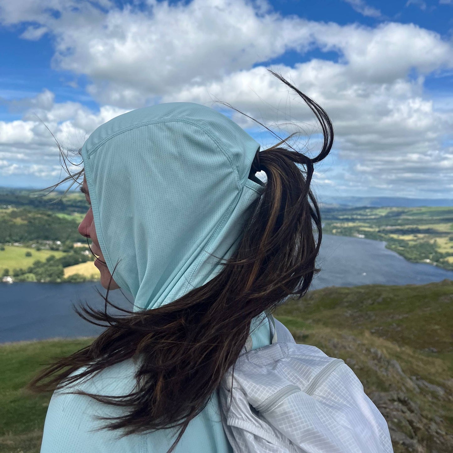 Woman wearing the Soltera Hoody with the hood up, above Ullswater in the Lake District