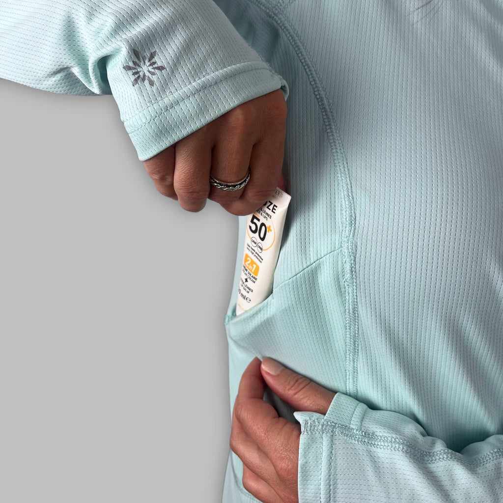 Close-up of the Soltera Hoody chest pocket holding a tube of sun cream